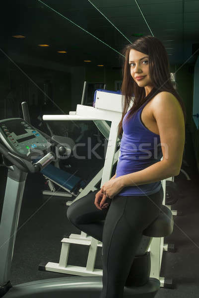 Stock photo: Smiling woman on a bicycle simulator