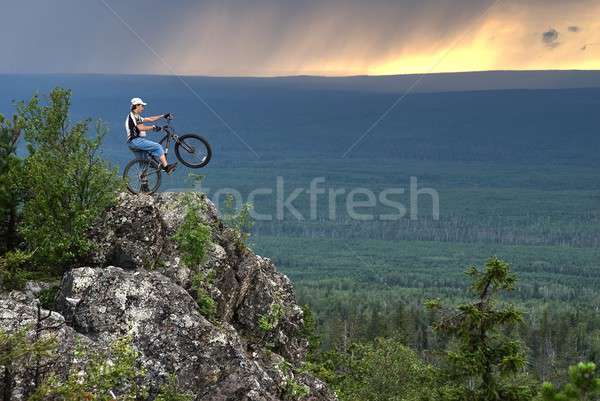 Biker with mountain bicycle stands on peak Stock photo © Aikon