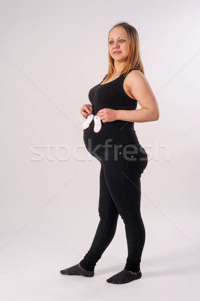 Mooie zwangere vrouw baby sokken studio portret Stockfoto © Aikon