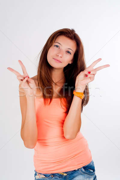Attractive girl with freckles shows victory sign Stock photo © Aikon