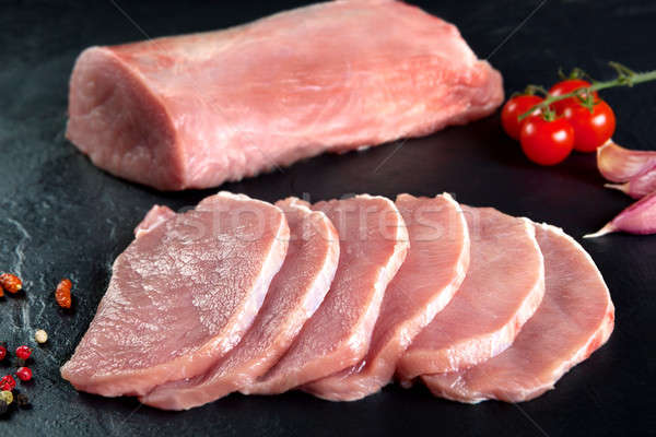 Fresh and raw meat. Pork tenderloin, loin  medallions steaks in a row ready to cook. Background blac Stock photo © Ainat