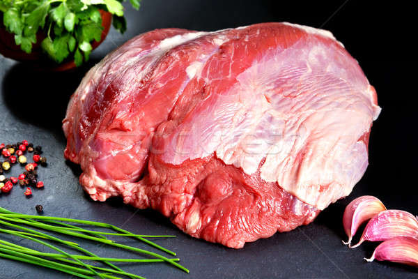 Fresh and raw meat. Whole piece of red meat ready to cook on the grill or BBQ .Background black blac Stock photo © Ainat