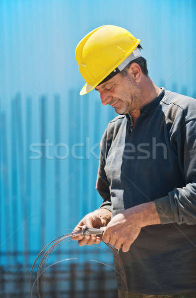 Construction worker cutting wire with pair of pliers Stock photo © akarelias