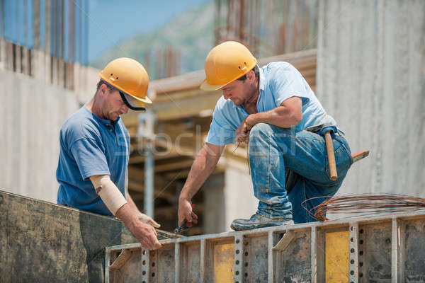 Stock photo: Two construction workers installing concrete formwork frames