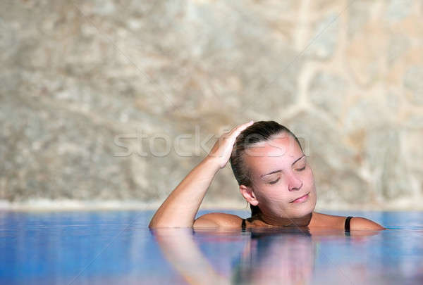 Young woman cools off in pool Stock photo © akarelias