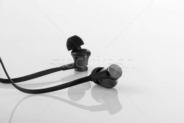 Stylish Black Earphones on White Reflective Background Stock photo © Akhilesh
