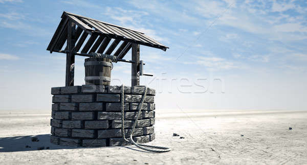 Wishing Well With Wooden Bucket On A Barren Landscape Stock photo © albund