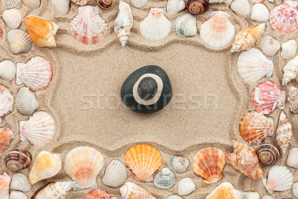 Rock cairn on the sand among sea shells Stock photo © alekleks
