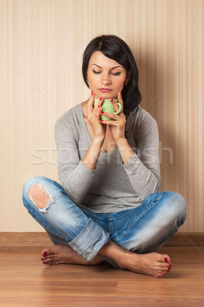 Beautiful girl sitting on the floor drinking from a green mug Stock photo © alekleks