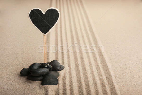 Pointer heart  standing  in the stones on the sand Stock photo © alekleks