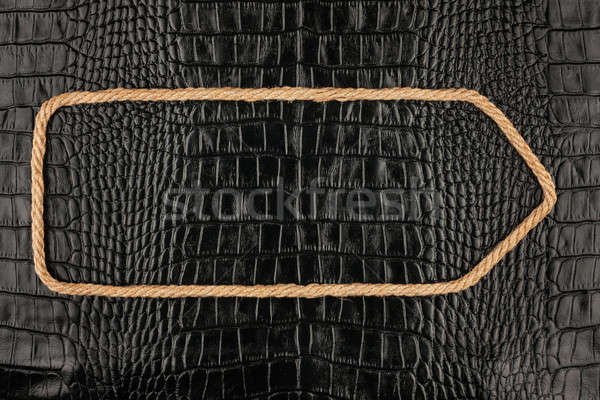 Arrow made of rope  lies on a background of crocodile  leather Stock photo © alekleks