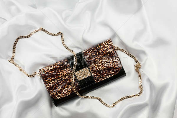 Leopard lacquer bag lying on a white silk Stock photo © alekleks