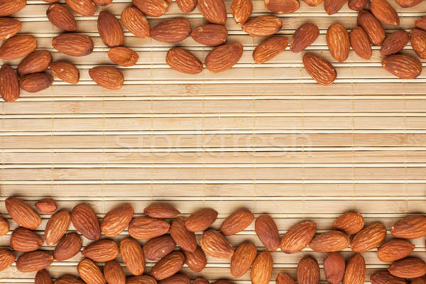 Stock photo: Almond lies on the a bamboo mat