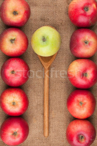 Spoon with green apple lying on the sackcloth among red apples Stock photo © alekleks