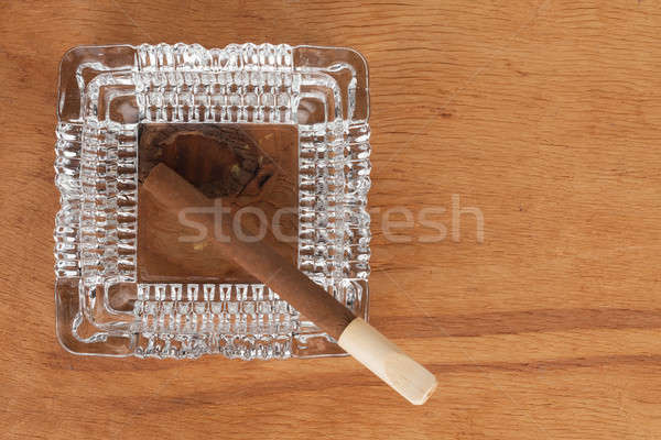 Glass ashtray with cigar stands on a wooden surface Stock photo © alekleks