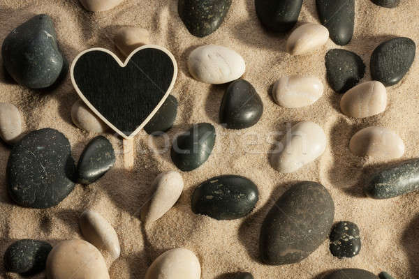 Close-up of stones and heart sticking out of the sand in the sun Stock photo © alekleks