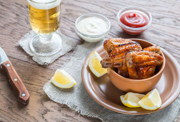 Caramelized chicken wings with glass of beer Stock photo © Alex9500