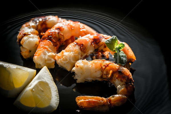 Fried shrimps with lemon wedges on the black background Stock photo © Alex9500