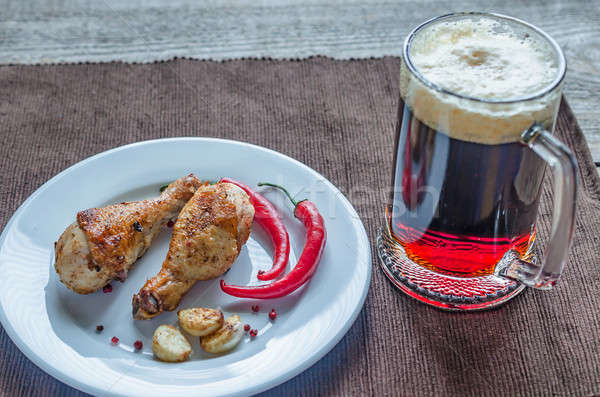 Grilled chicken drumsticks with a mug of beer Stock photo © Alex9500