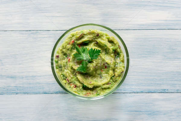 Bowl of guacamole on the wooden table Stock photo © Alex9500