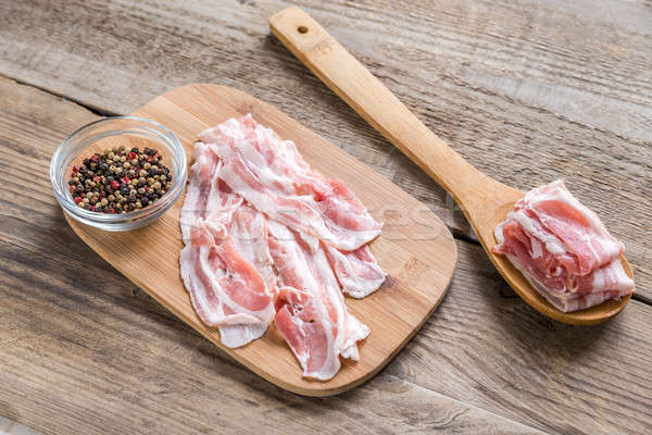 Bacon strips with pepper on wooden board Stock photo © Alex9500