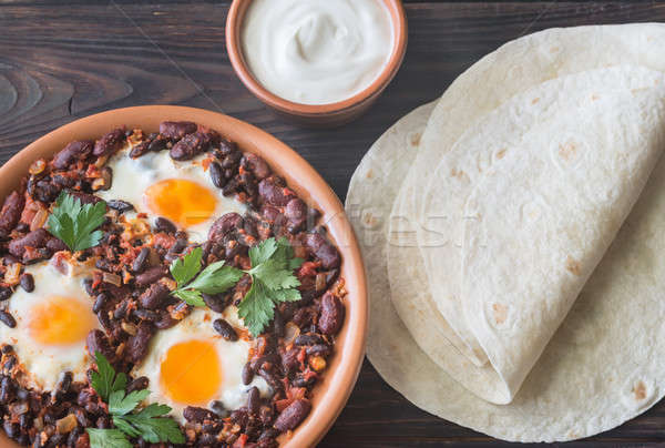 Bowl of chipotle bean chili with baked eggs Stock photo © Alex9500