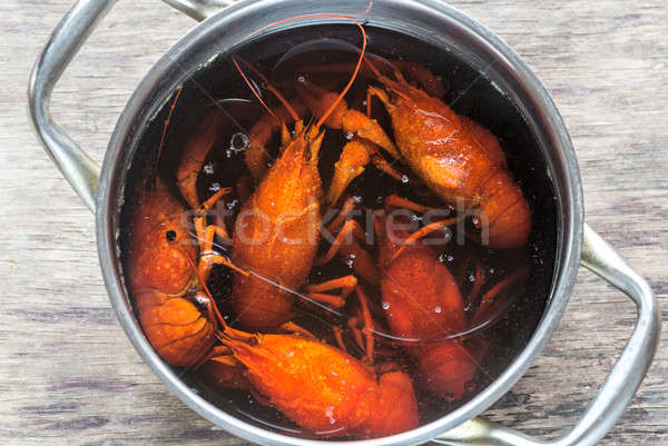 Pot with boiled crayfish on the wooden table Stock photo © Alex9500