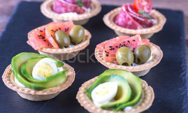 Tartlets with different fillings on the stone board Stock photo © Alex9500