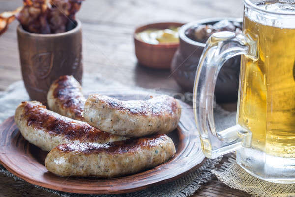 Stock photo: Grilled sausages with fried bacon rashers and mushrooms