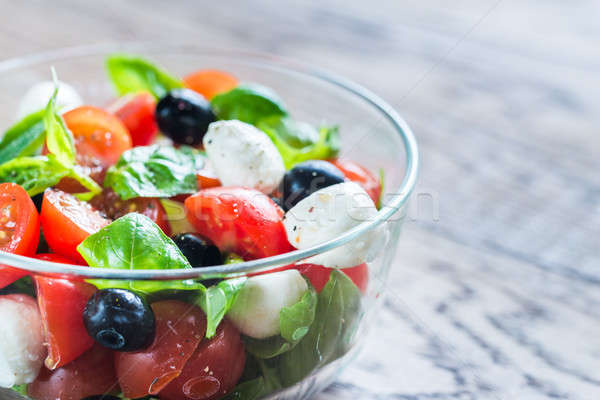 Salad with tomatoes, olives, mozzarella and basil Stock photo © Alex9500