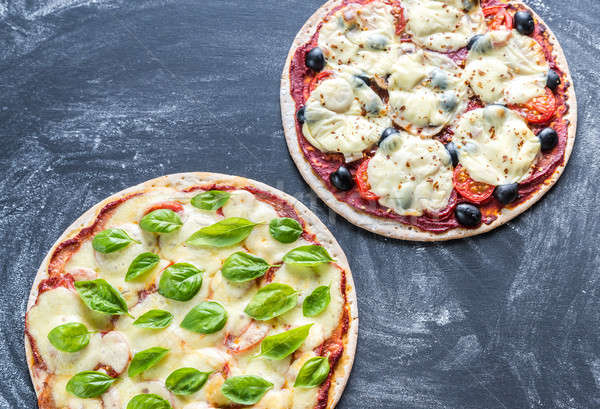 Two pizzas with ingredients on the wooden background Stock photo © Alex9500