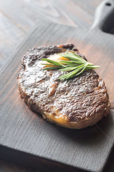 Stock photo: Beef steak with fresh rosemary on the wooden board