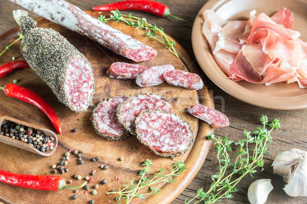 Slices of saucisson, jamon and salami on the wooden board Stock photo © Alex9500