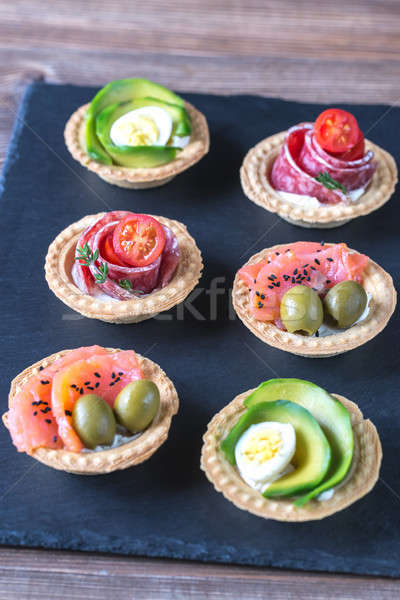 Tartlets with different fillings on the stone board Stock photo © Alex9500