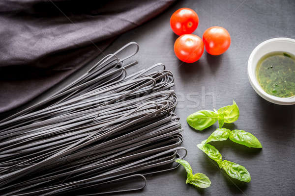 Raw black pasta with basil and tomatoes Stock photo © Alex9500