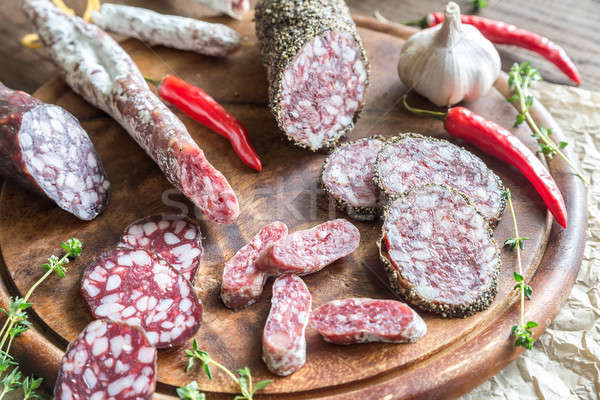 Slices of saucisson, fuet and salami on the wooden board Stock photo © Alex9500