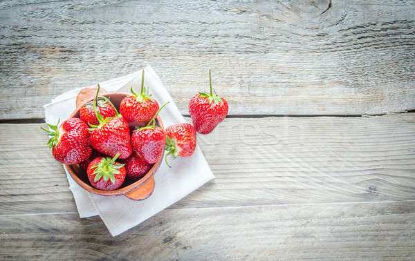 Fresh strawberries in the bowl on the wooden table Stock photo © Alex9500