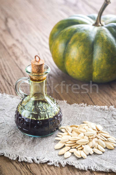 Bottle with pumpkin oil on the wooden background Stock photo © Alex9500