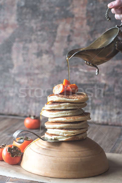 Pancakes with fresh persimmon and maple syrup Stock photo © Alex9500