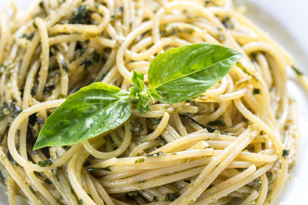 Stock photo: Portion of pasta with pesto sauce and basil leaf