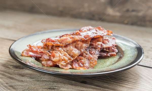 Stack of fried bacon strips on the plate Stock photo © Alex9500