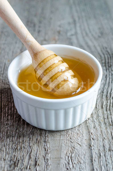Honey bowl with dipper and flowing honey Stock photo © Alex9500