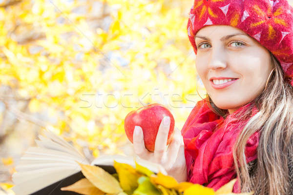 Charming girl with apple in the autumn park and reads book   Stock photo © alexandkz