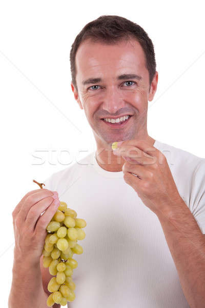 Zdjęcia stock: Przystojny · mężczyzna · jedzenie · zielone · winogrona · odizolowany · biały