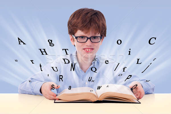 cute boy reading a book on his desk, with flying letters, Stock photo © alexandrenunes