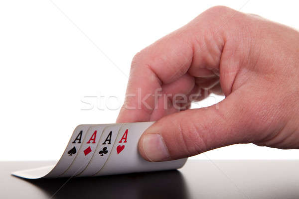 Stock photo: man's hand revealing four aces