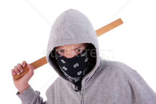 Stock photo: A teen with a stick, in a act of juvenile delinquency