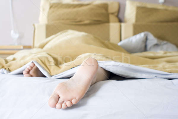 Reggel lány ágy fény otthon láb Stock fotó © alexeys