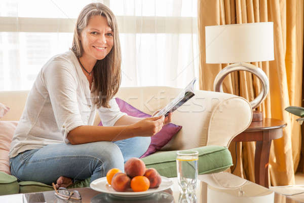 Vrouw bank magazine rijpe vrouw ontspannen appartement Stockfoto © alexeys