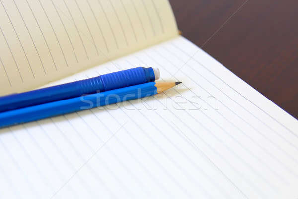 Drawing pencil and eraser over a white notebook Stock photo © alexmillos